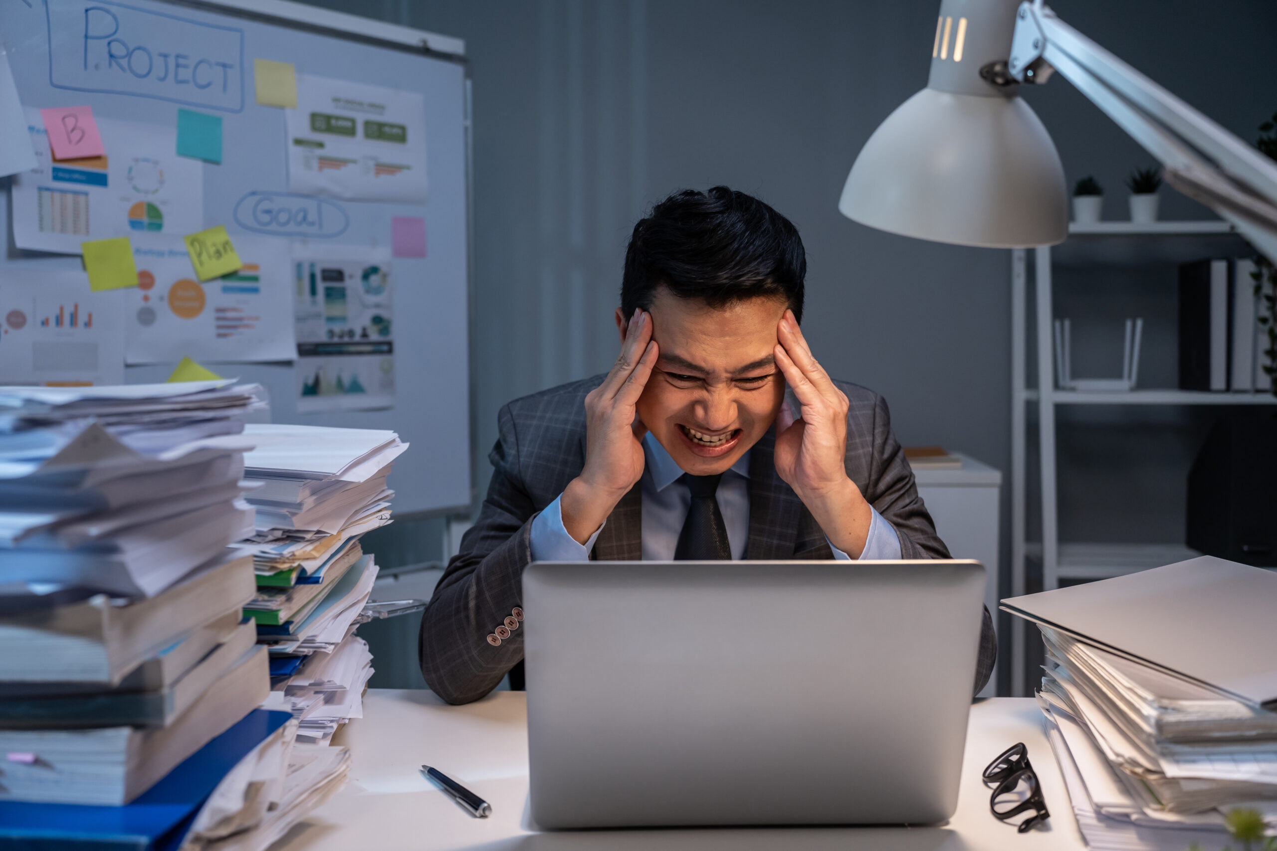 Depressed Asian male feel worried about financial problem in business. Stressed desperate handsome man look frustrated to sale order on laptop and think of money debt, budget loss, bankruptcy at store
